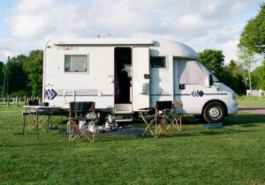A motorhome parked up with camping furniture outside