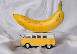 A banana atop a miniature yellow camper van