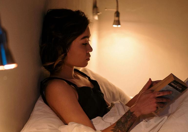 A woman reading a book in bed