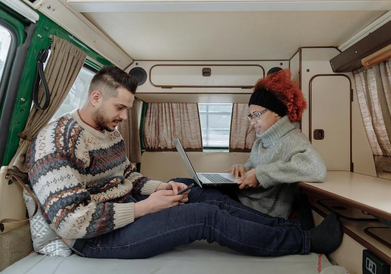 Couple looking up caravan insurance inside their leisure vehicle