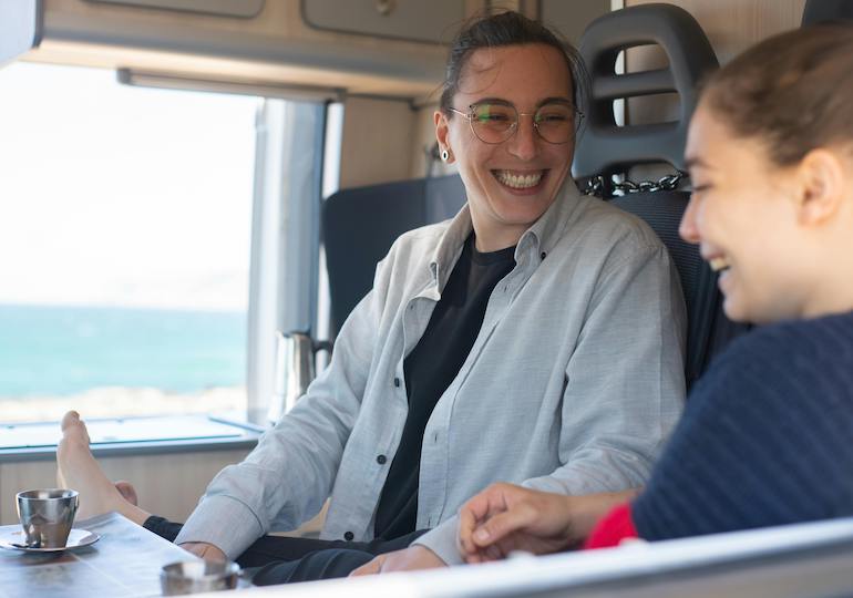 Two women relaxing inside a caravan