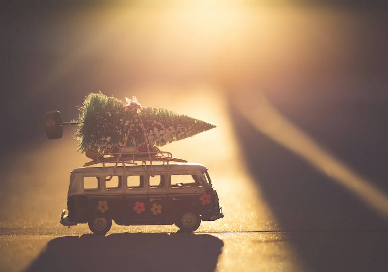 A toy camper with a Christmas tree strapped to its roof